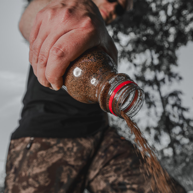 black fire special lockmittel ausgeschuettet auf waldboden szenebild fuer jagdverwendung