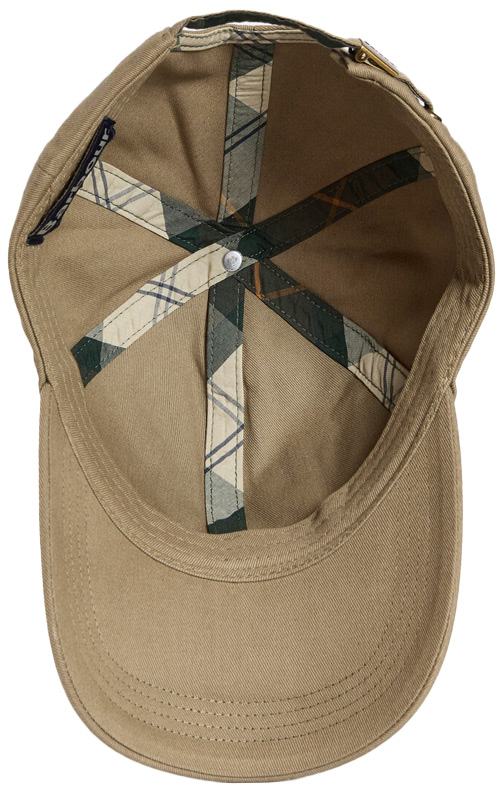 Barbour Cap Milburn wird von unten gezeigt, sodass die Innenseite sichtbar ist. Die Farbe der Kappe ist hellbraun, auf der Innenseite findet sich das typische Barbour Tartanmuster auf nahtverstärkenden Stoffstreifen