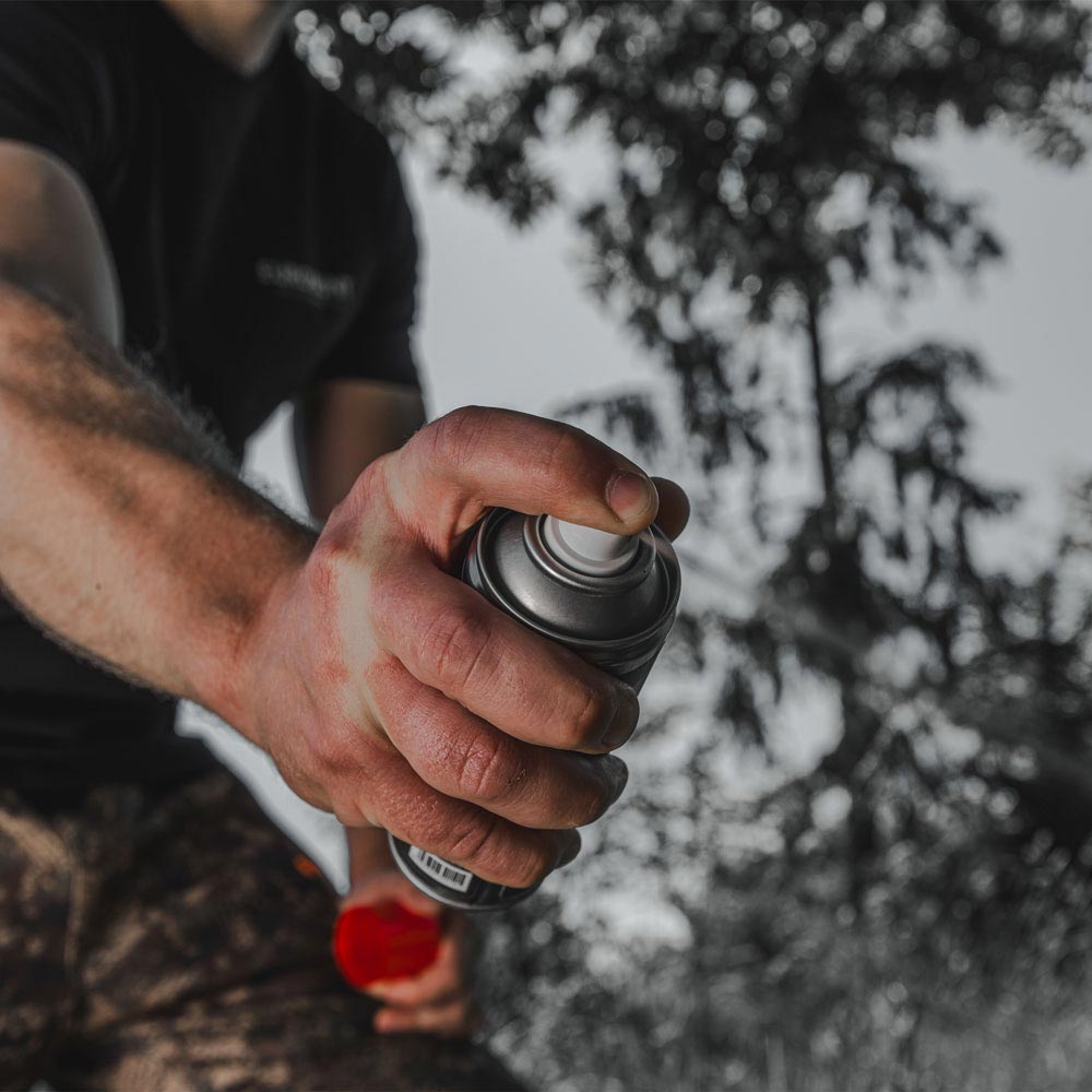 black fire magic spray gesprueht auf baumstamm oder waldboden lockmittel jagdszene